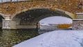 Clear Panorama Snowy trail along lake and passing under a bridge