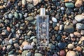 Clear perfume bottle laying on the wet stones