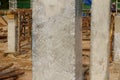 Clear plastic covers concrete columns to prevent water loss in concrete on the construction site. The concrete curing process