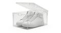 Clear plastic shoe box displaying white high top sneakers Royalty Free Stock Photo