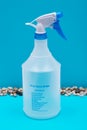 Clear Plastic Spray Bottle made with up to 10% recycled material with blue handle isolated on blue