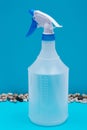 Clear Plastic Spray Bottle made with up to 10% recycled material with blue handle isolated on blue