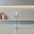 Clear plastic spray bottle with a white nozzle on a light-colored countertop. The Royalty Free Stock Photo