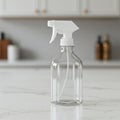 A clear plastic spray bottle with a white trigger nozzle is centered on a white marble Royalty Free Stock Photo
