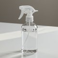 Clear plastic spray bottle with a white trigger on a white surface. The bottle is filled w Royalty Free Stock Photo