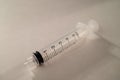 Clear Plastic Syringe on White Background with Drastic Shadows