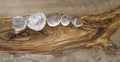 Clear quartz crystals on olive wood background