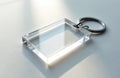 Clear rectangular acrylic keychain sits on white surface. Metal ring attached. Empty slot for photo insert. Blank accessory for Royalty Free Stock Photo