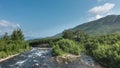 A clear river flows in the valley along a rocky bed Royalty Free Stock Photo