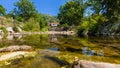 Clear river, stones, vegetation, houses. Carmona, Cantabria, Spain