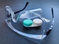 clear safety glasses, clear solution bottle and contact lens container.