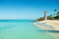 Clear sea, white sand, tropical palm trees and lighthouse on sandy shore Royalty Free Stock Photo