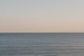 Clear sky and sea at sunset, unidentified sailboat in the distance on horizon Royalty Free Stock Photo