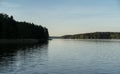 Clear sky and tall trees reflected on the still water of the Jeziorak lake Royalty Free Stock Photo