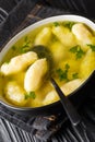 Clear soup with semolina dumplings close up in a dish. vertical