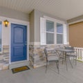 Clear Square Exterior of a home with blue wooden front door and reflective glass windows