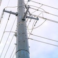 Clear Square Looking up at a towering metal post supporting overhead power lines