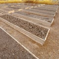 Clear Square Rows of raised wooden garden beds with faucets and filled with coarse brown soil