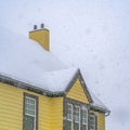 Clear Square Snowy yellow home viewed through falling snow