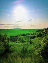 The clear summer sun, shining in a blue sky, illuminates the emerald fields and meadows, creating a captivating landscape. Royalty Free Stock Photo