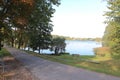 Clear sunny day and calm surface of Lake Birini with deciduous trees on the green shore Royalty Free Stock Photo