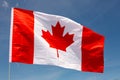 National flag of Canada flies on flagpole against blue sky Royalty Free Stock Photo