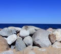 A clear sunny summer day by the sea or lake. big stones on the shore and blue clear sky