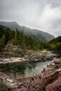 Clear teal waters of Haystack Creek along Going to the Sun Road in Glacier National Park. Overcast cloudy day