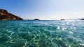 Clear turquoise water of Aegean sea. Beautiful Mediterranean seascape of ripple water with sunbeams reflections. Selective focus.