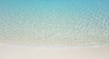 Clear turquoise water gently laps onto a pristine white sandy beach. The shallow wate Royalty Free Stock Photo