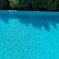 Clear turquoise water in a swimming pool reflects sunlight, creating a pattern of Royalty Free Stock Photo