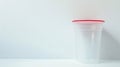 Clear urine specimen cup with red top. Sterile plastic container for medical use. Concept of health screening Royalty Free Stock Photo
