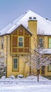 Clear Vertical Winter home with frosty trees on the snow covered front yard in Daybreak Utah