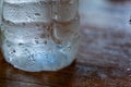 The Clear water drop on cool water bottle on wooden table