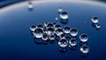 Clear water droplets scattered on a deep blue reflective surface Royalty Free Stock Photo