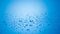 Clear water droplets scattered on a smooth blue surface Royalty Free Stock Photo