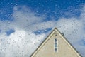 Clear water drops on clean window glass with a house in the background.