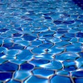 Clear water ripples over blue tiles, forming a mesmerizing abstract