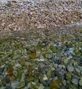 Clear water with round colorful rocks