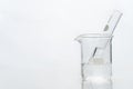 Water in test tube and glass science beaker in white chemistry background