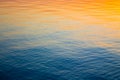 Clear water texture in blue and orange. Background of the ocean and the sea backlit by the sun. Soft waves. Natural water Royalty Free Stock Photo