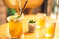 Clear wellness yellow drink lemonade, fruit ice kombucha, green chia seed tea with reusable glass straw in glassfull on