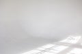 Clear white cyclorama. Light background with sun light and shadows. Plain wall empty photo studio. Royalty Free Stock Photo