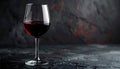 A glass of red wine on a dark stone surface with a textured background Royalty Free Stock Photo
