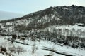 A clearing in the bed of a frozen river flowing at the foot of a high mountain in winter Royalty Free Stock Photo