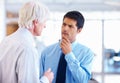 Clearing doubts. Portrait of doubtful business man listening to senior executive at office.