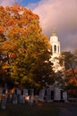 A clearing sky helps illuminate a church during autumn