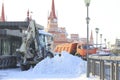 Clearing snow from the road with bulldozer and truck in the city