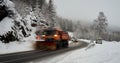 Clearing vehicle clears a road in the Harz Mountains of freshly fallen snow, a line of cars follows the snow shovel