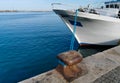 Cleat with blue hawser on the blue sea and white boat